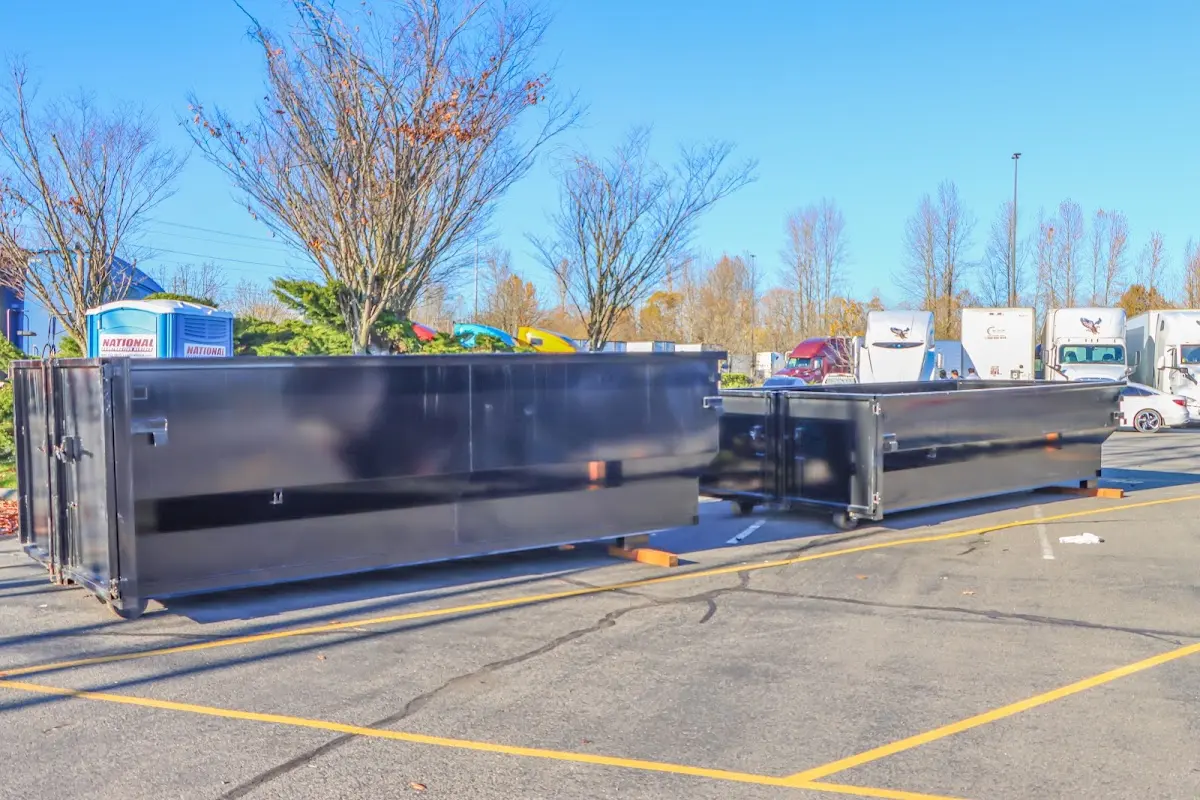 Professional dumpster rental service with roll-off container on residential driveway in Elwood